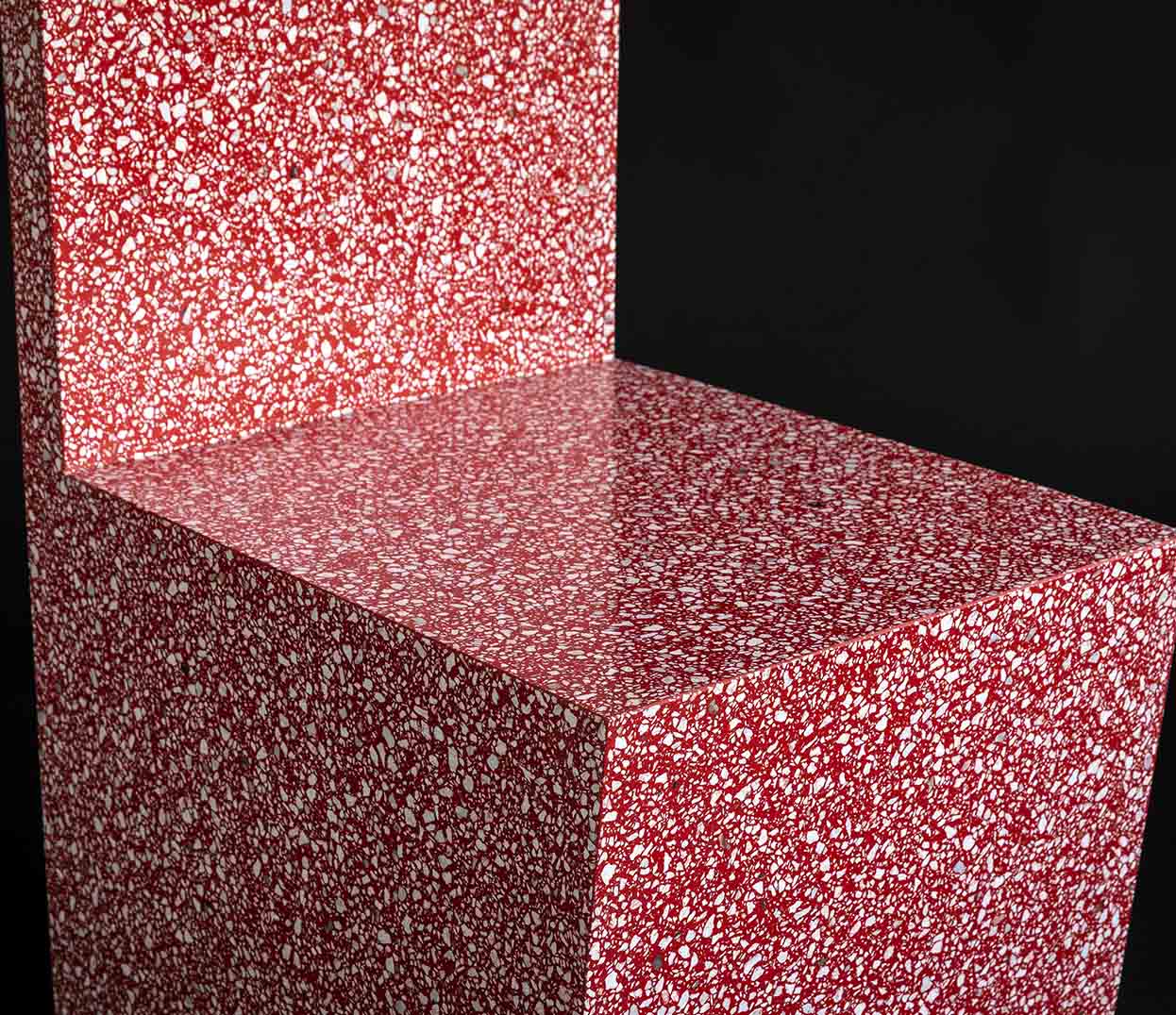 massive red chair made of terrazzo